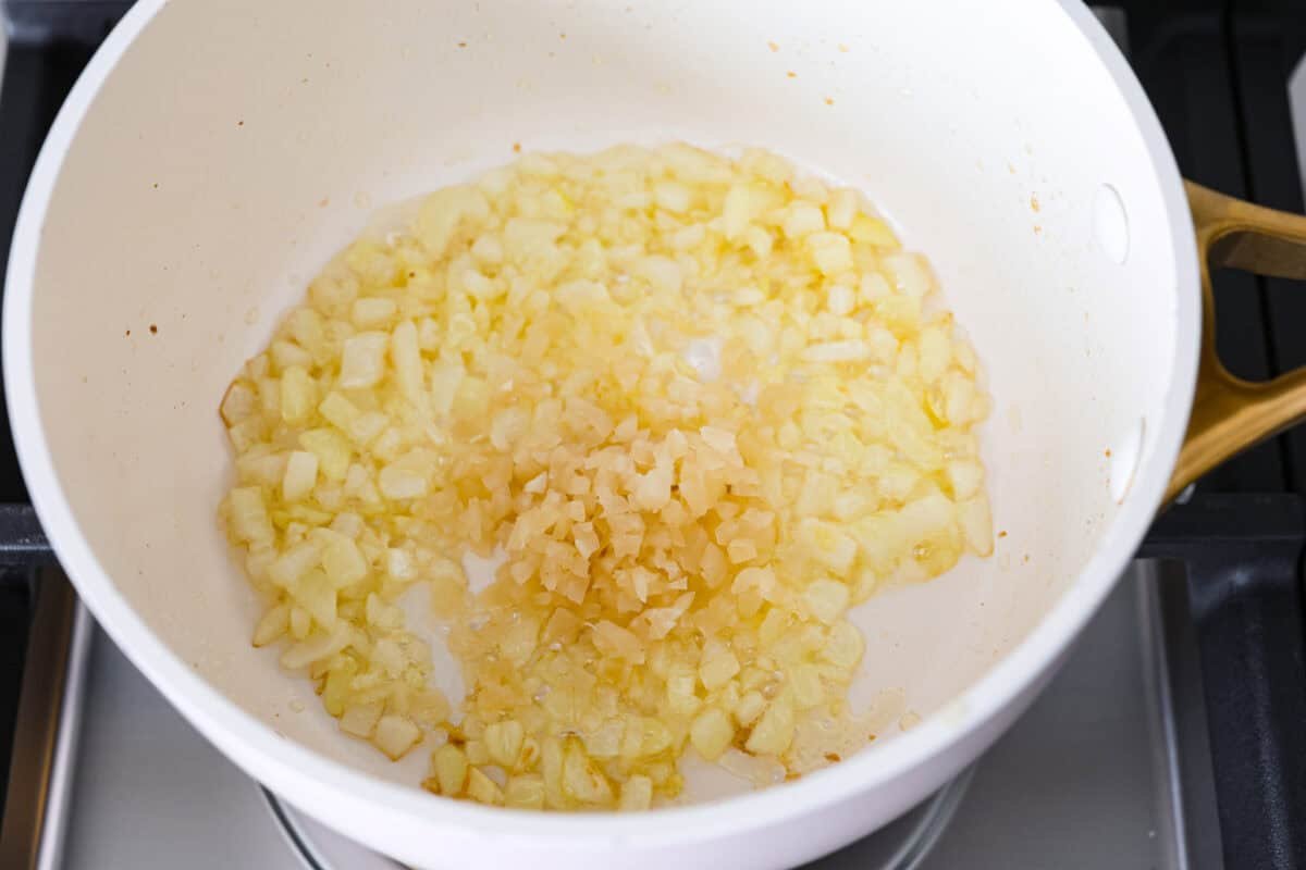 Overhead host of butter and onion mixture with garlic on top. 