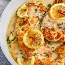 Chicken Francese in a pan with lemon slices