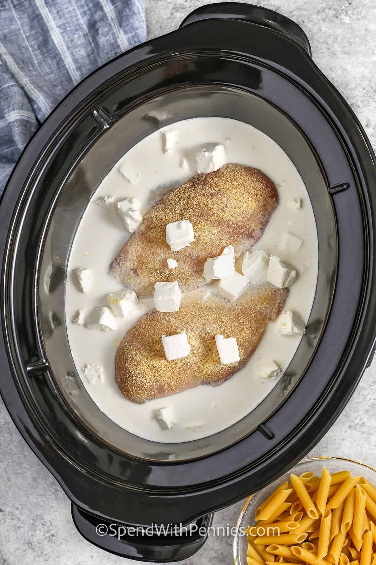 adding seasoned chicken , half and half , cream cheese to pot to make Crock Pot Chicken Alfredo