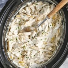 pot of Crock Pot Chicken Alfredo with a spoon