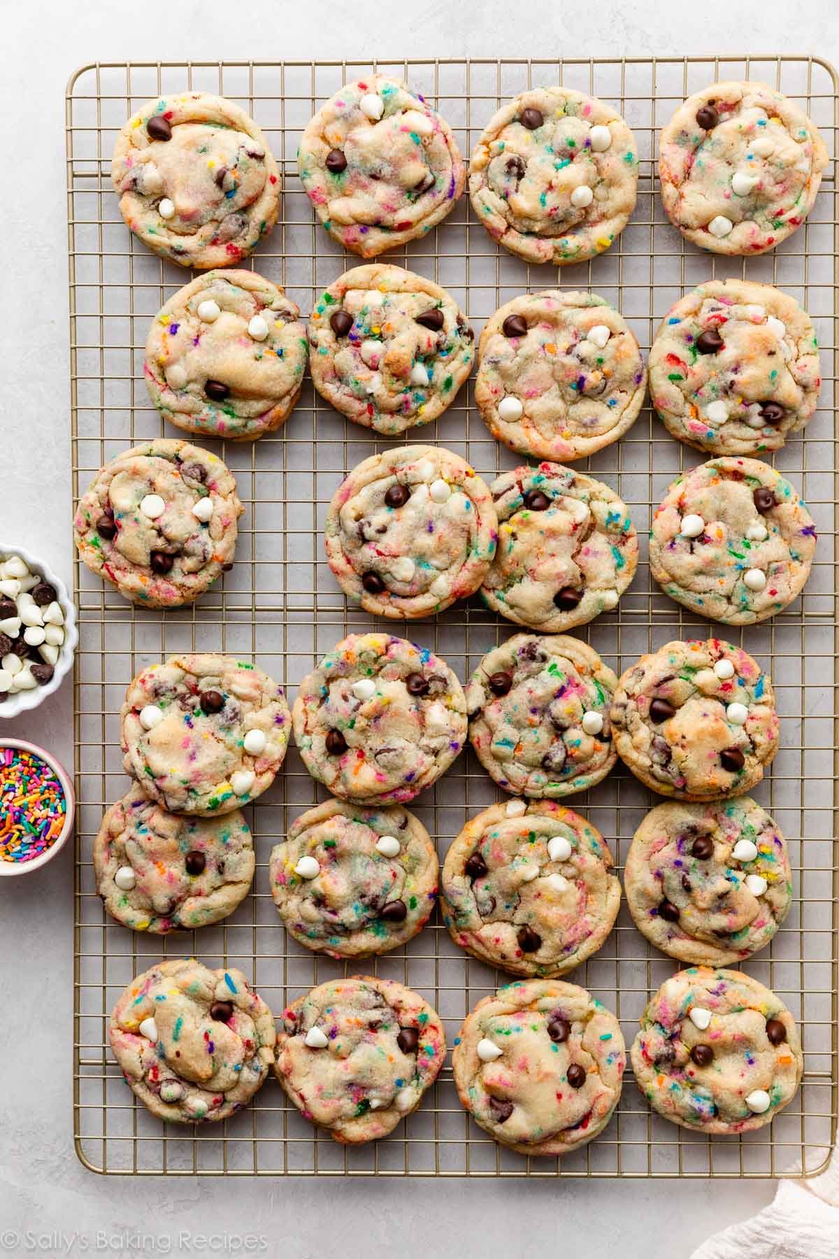 sprinkle chocolate chip cookies on gold cooling rack.