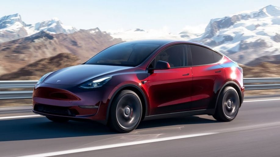 2024 Tesla Model Y driving on a road.