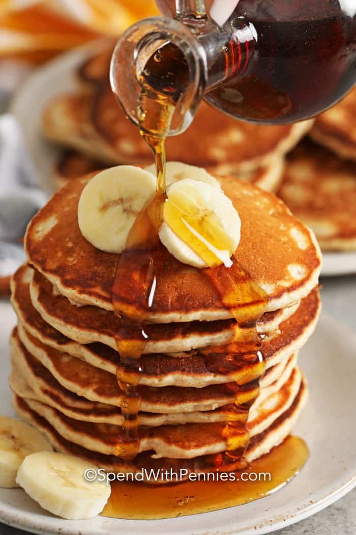 Banana Pancakes with bananas and syrup being poured on