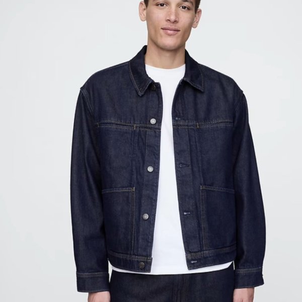 a man wearing  denim jacket over a crew neck shirt