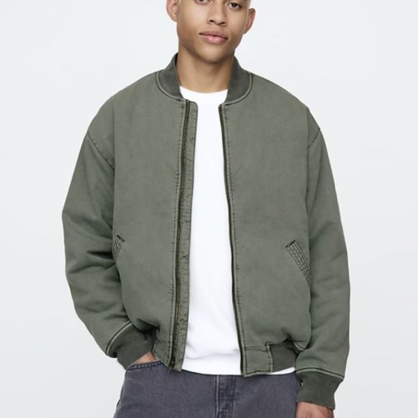 a man wearing a zip front bomber style jacket over a crew neck shirt