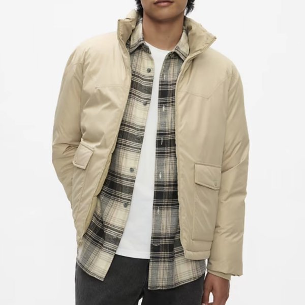 a man wearing a puffer jacket layered over a button front shirt and crew neck shirt