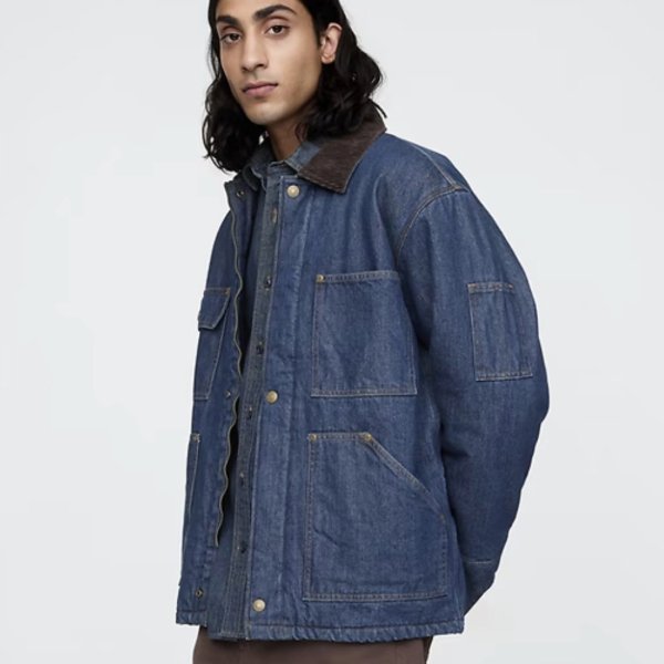 a man wearing an oversized denim chore style coat